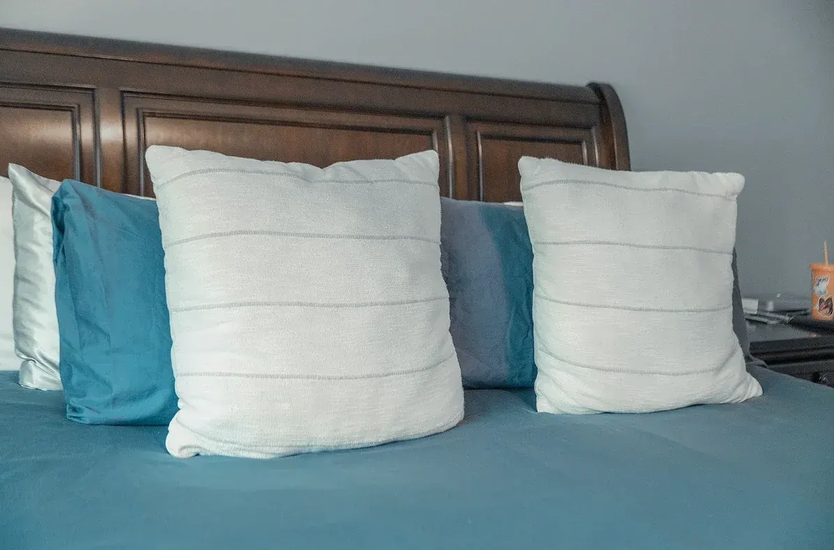 Almohadas recién acomodadas sobre una cama tendida