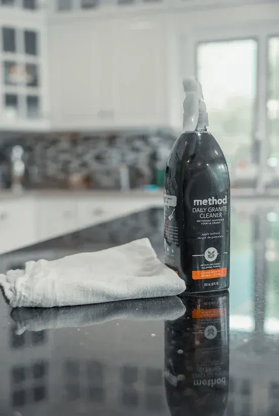 Granite countertop with cleaner and a white cloth