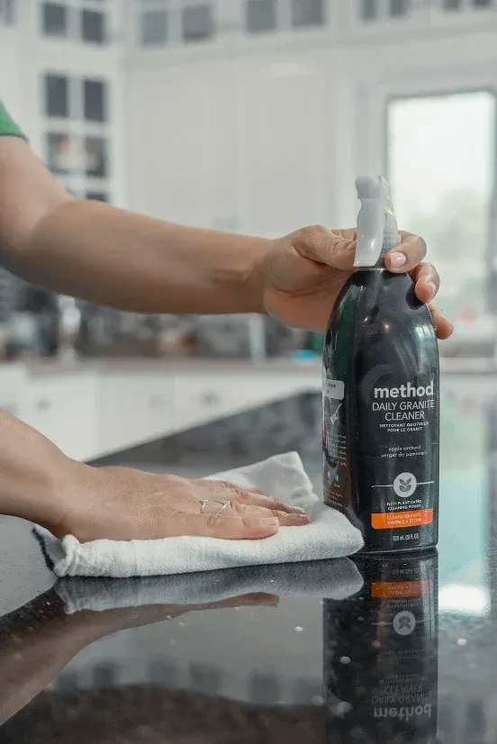 Team member wiping a granite countertop