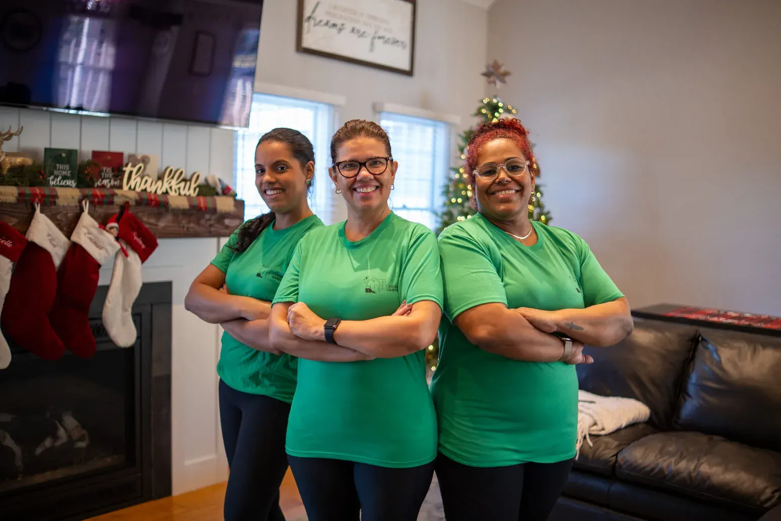 Three 520 Cleaning Solutions team members smiling in a client's living room